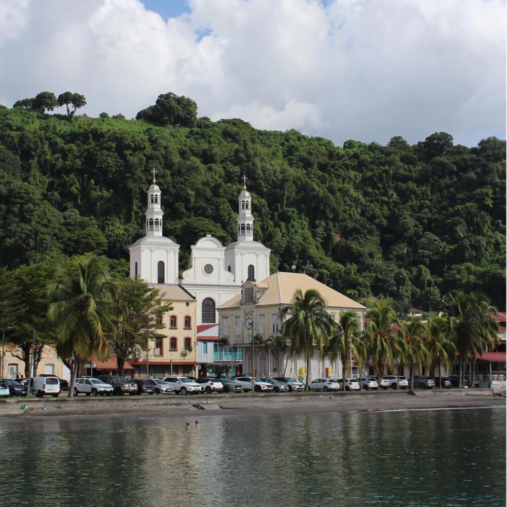 Picturesque view of a tropical church in Saint-Pierre, Martinique, with lush greenery.
