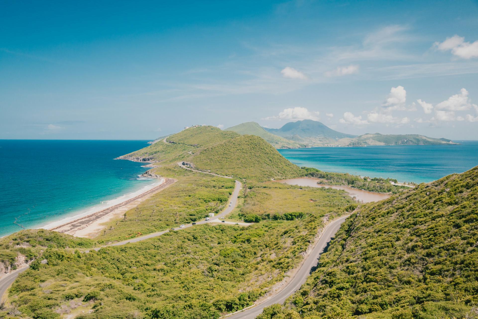 View from Timothy Hill over the green southeast peninsula of St Kitts, with the Atlantic Ocean and Caribbean Sea on either side
