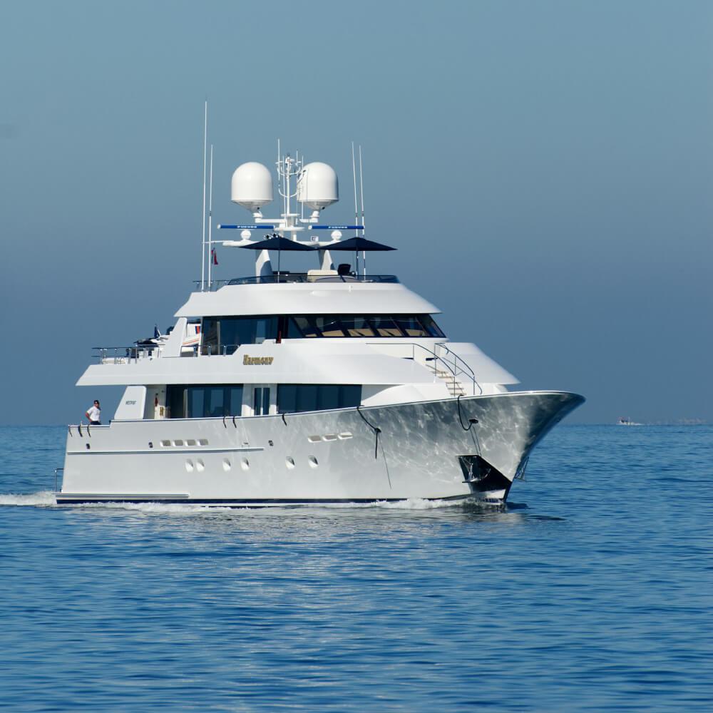 A white yacht at anchor in a sheltered bay