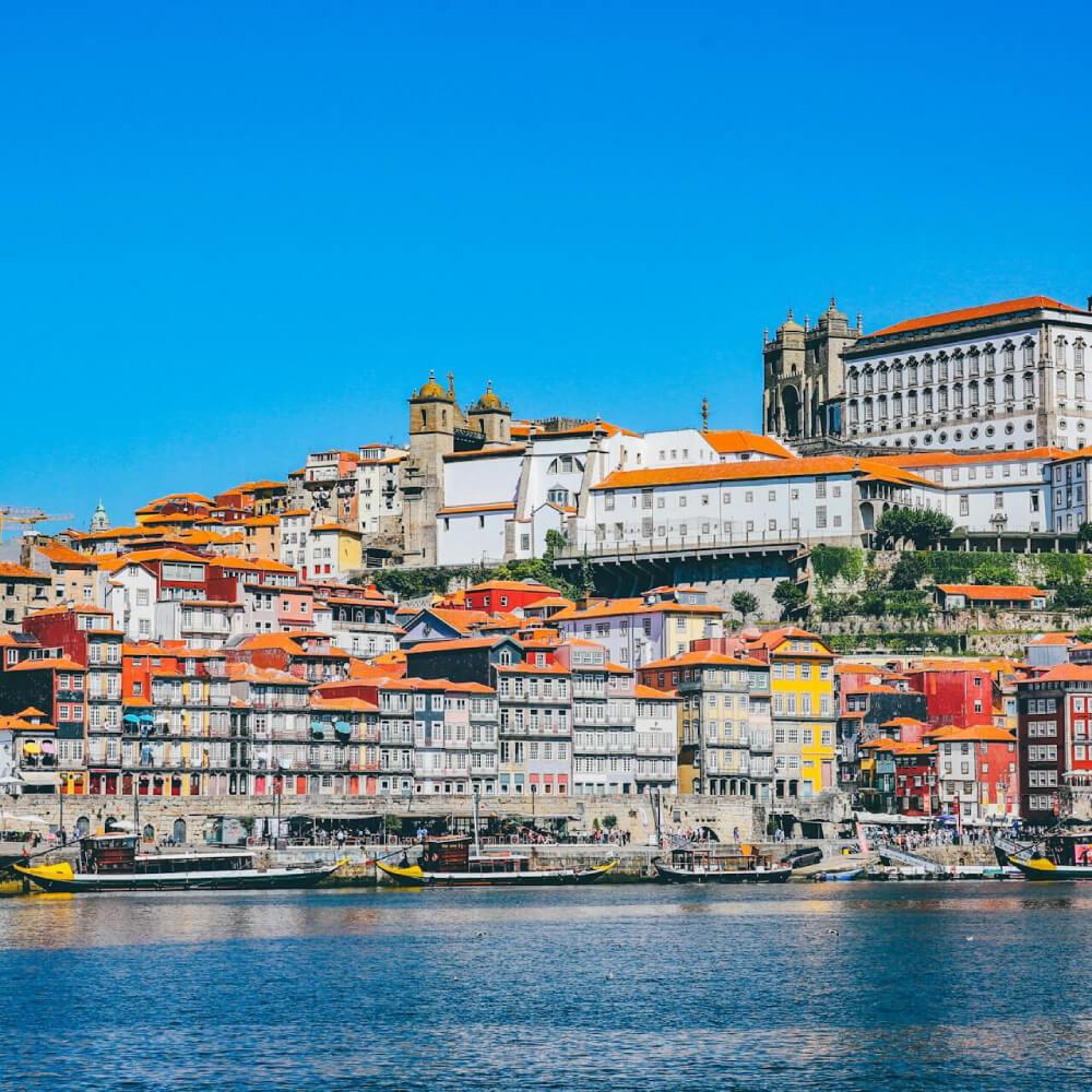 The Ribeira waterfront in Porto, with rabelo boats on the Douro and the cathedral above