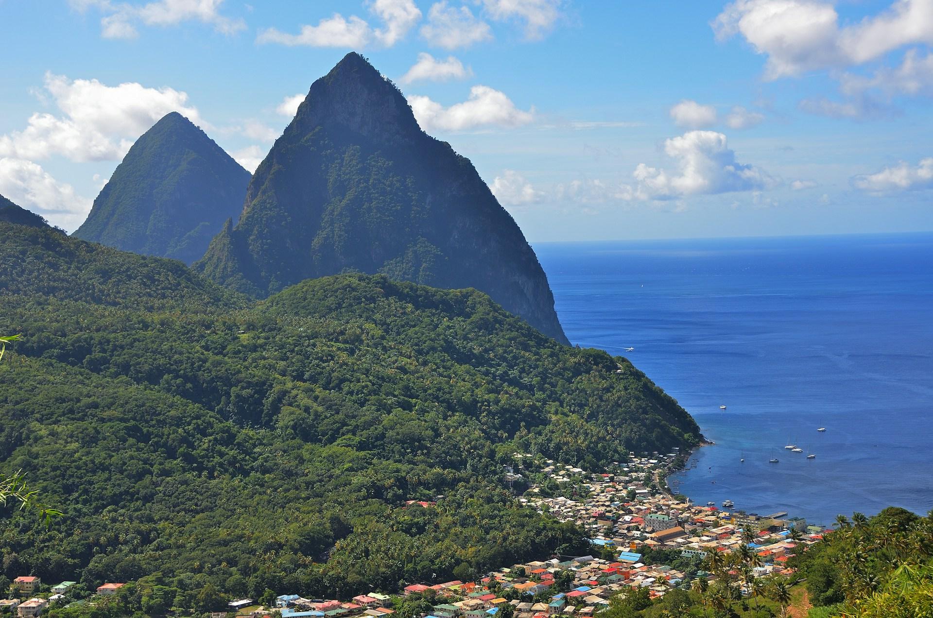 The Pitons above a coastal town and the blue Caribbean Sea in Saint Lucia