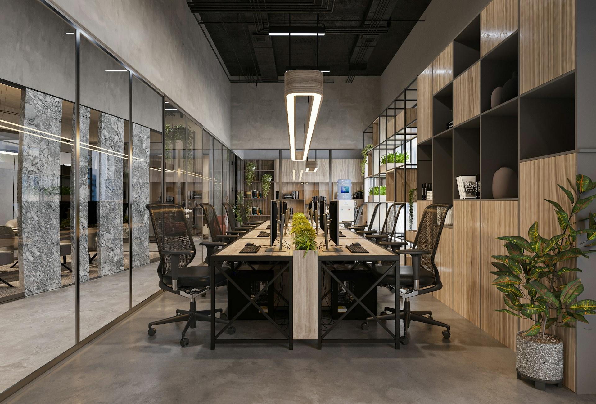 An empty Dubai office with shared desks, glass partitions and plants