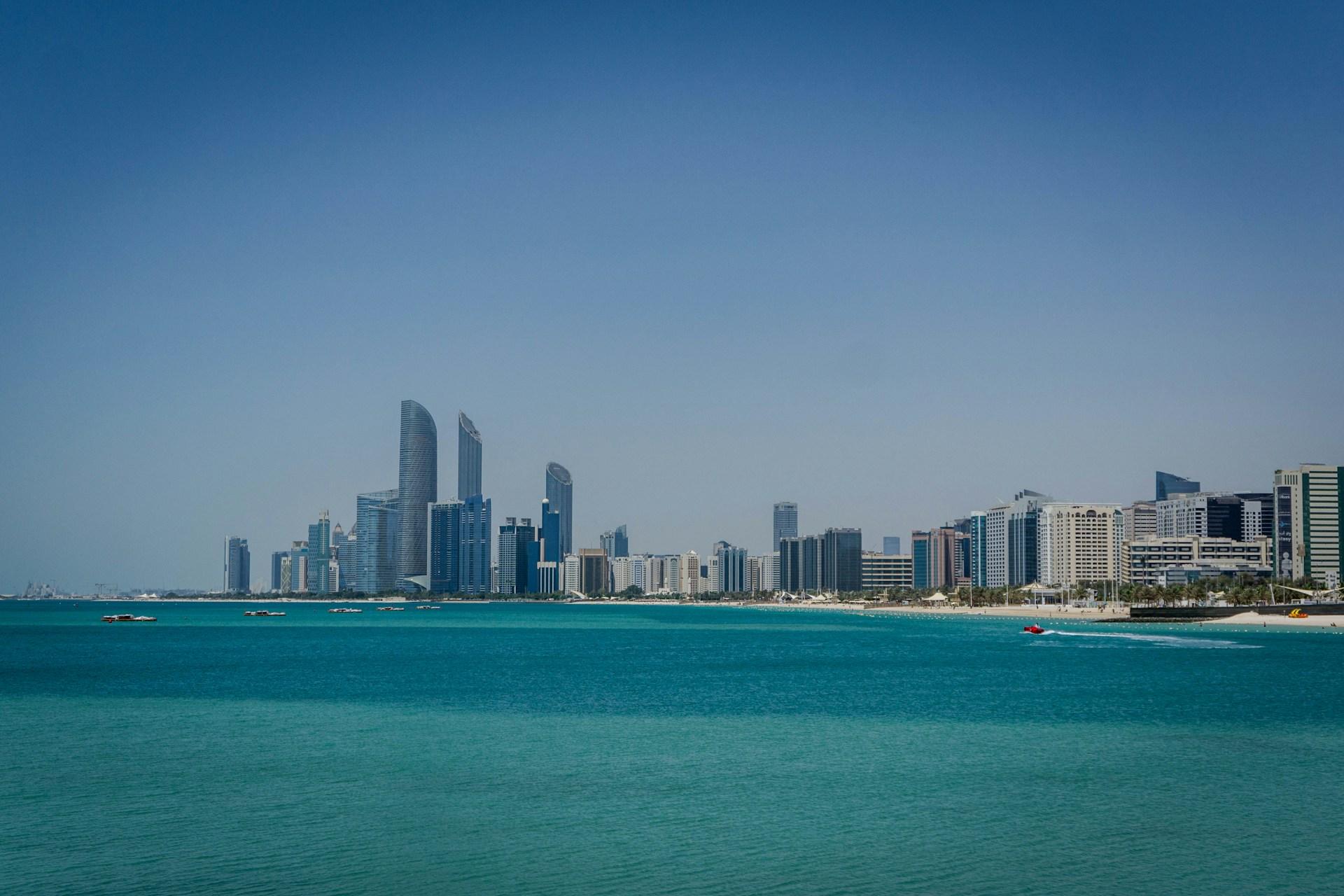 Abu Dhabi skyline with modern towers across turquoise water in the United Arab Emirates