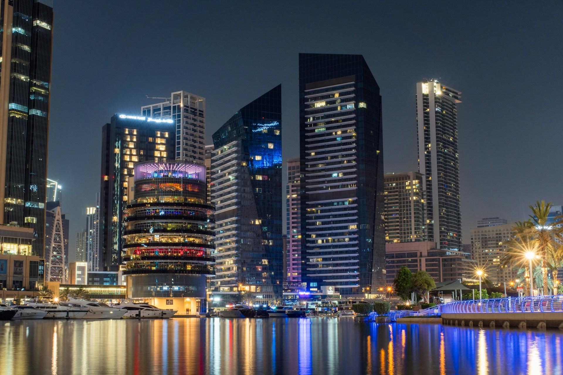 Illuminated skyscrapers reflected in the water at Dubai Marina, United Arab Emirates