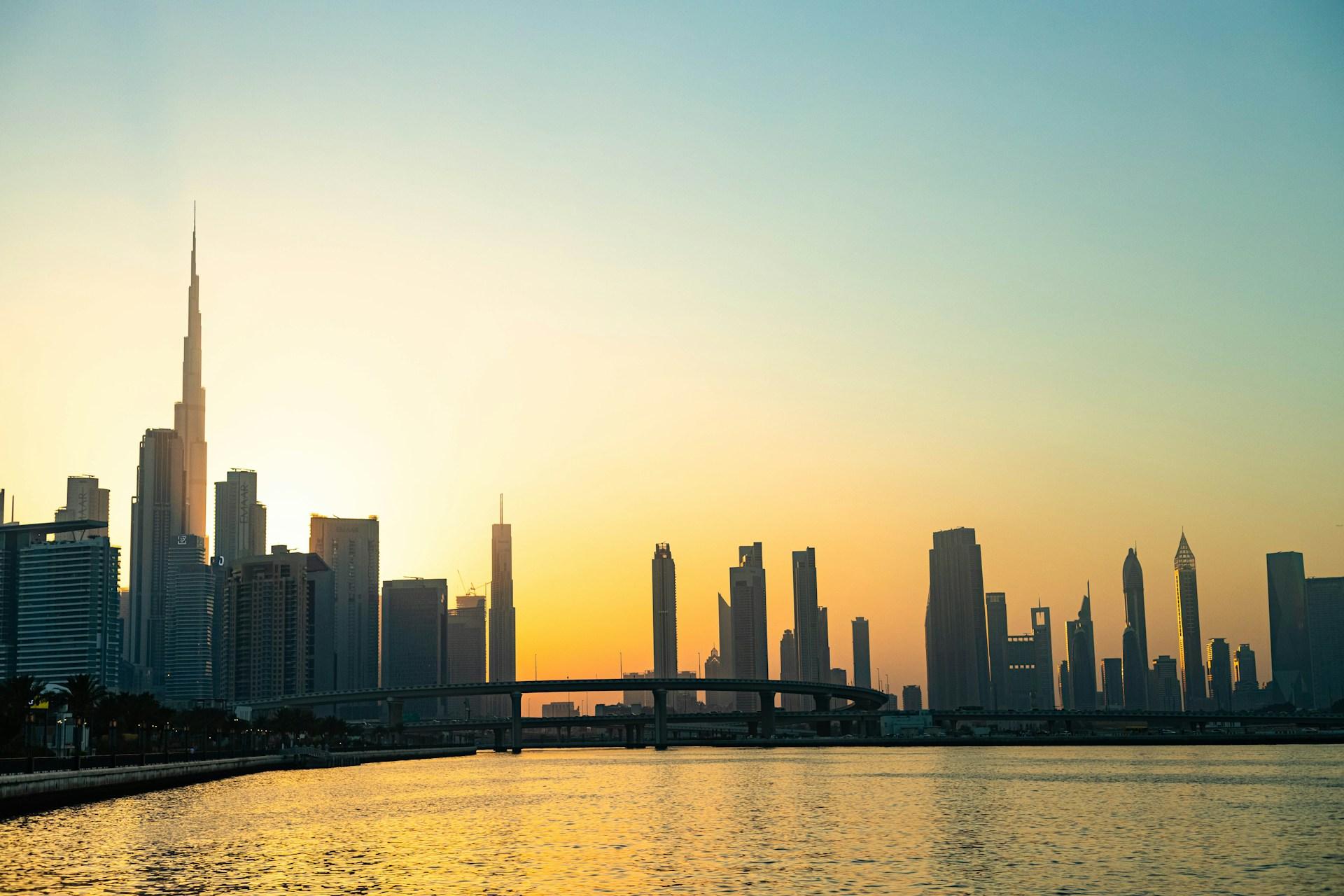 Dubai skyline and Burj Khalifa beside the water at sunset, viewed from Dubai Design District